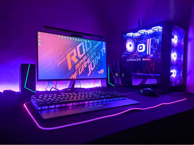 A gaming PC and keyboard lit in purple