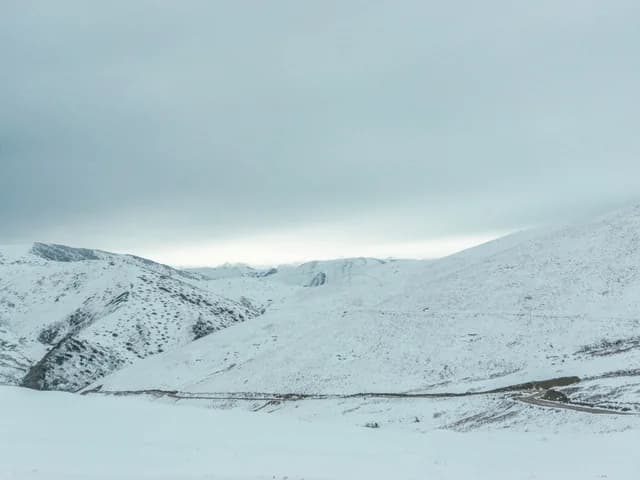 A snowbound mountain pass under heavy cloud